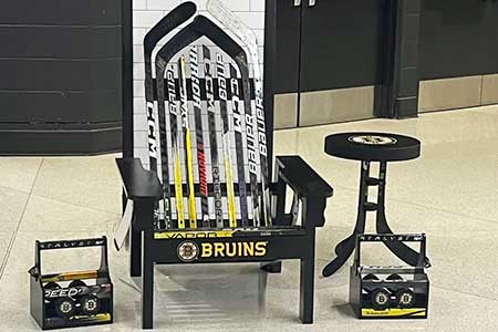 Adirondack chair made out of Bruins hockey sticks, two drinks caddies, and a side table.